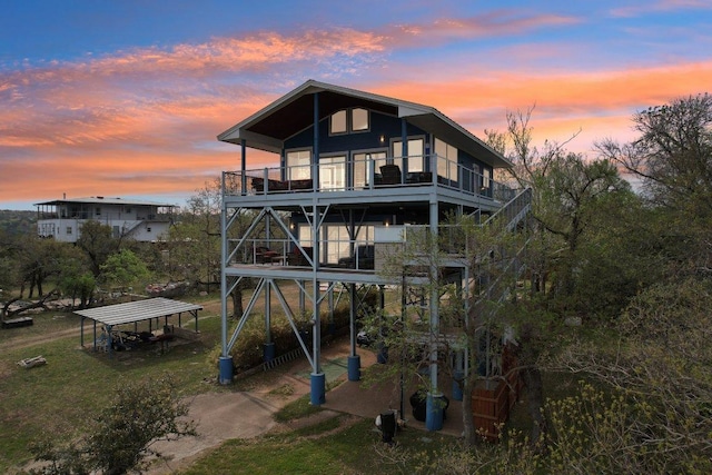 back of property with driveway, stairway, and a detached carport