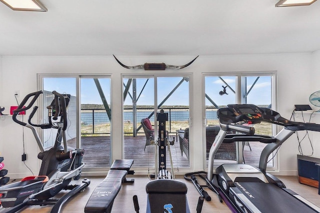 gym featuring a water view and plenty of natural light