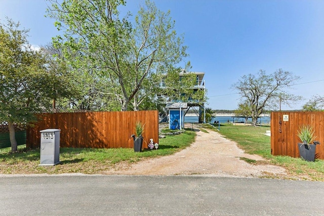 view of street with a water view and dirt driveway