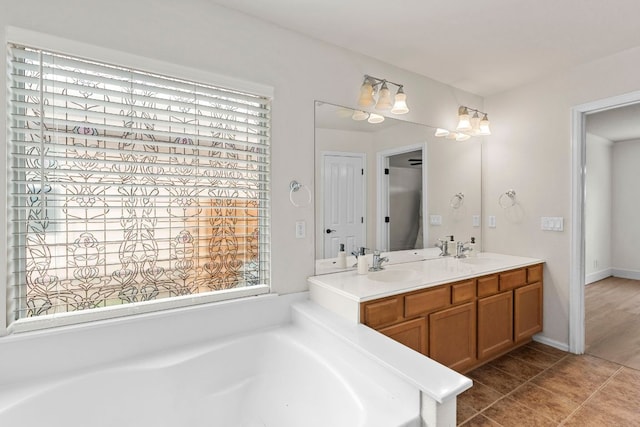 1290 Sweet Gum Dr, Kyle, TX 78640 - bathroom featuring plenty of natural light, double vanity, a bath, and tile patterned flooring
