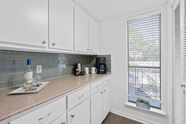1101 Hollow Creek Dr Unit 2203, Austin, TX 78704 - kitchen featuring tasteful backsplash, light countertops, dark tile patterned floors, and white cabinets
