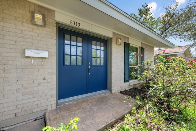 8313 Renton Dr, Austin, TX 78757 - doorway to property featuring french doors, a porch, and brick siding