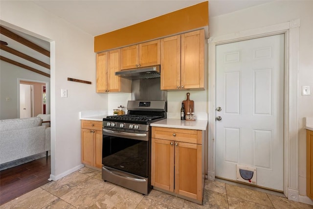 8313 Renton Dr, Austin, TX 78757 - kitchen with vaulted ceiling with beams, light countertops, under cabinet range hood, and stainless steel gas stove