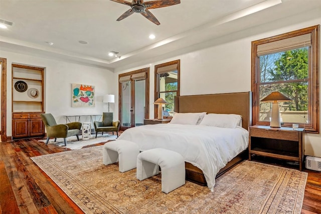 11 Hightrail Way, Austin, TX 78738 - bedroom featuring a tray ceiling, wood-type flooring, multiple windows, and recessed lighting