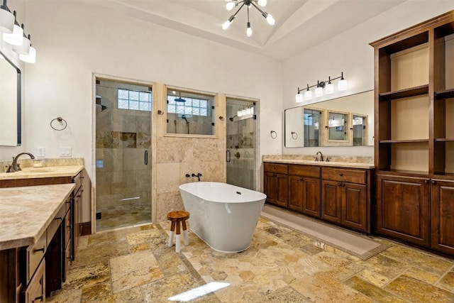 11 Hightrail Way, Austin, TX 78738 - full bathroom featuring stone tile flooring, a shower stall, two vanities, a freestanding tub, and a chandelier
