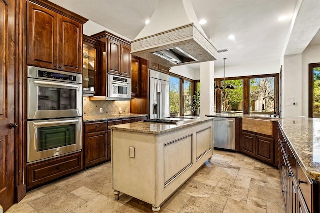 11 Hightrail Way, Austin, TX 78738 - kitchen featuring appliances with stainless steel finishes, stone tile flooring, tasteful backsplash, light stone countertops, and recessed lighting