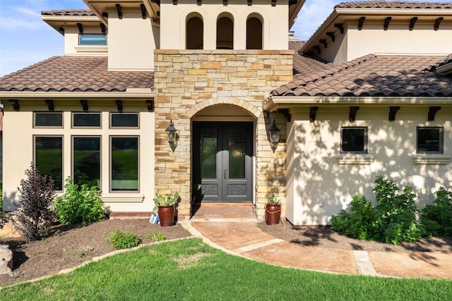 11 Hightrail Way, Austin, TX 78738 - entrance to property featuring french doors, a tiled roof, stucco siding, and stone siding