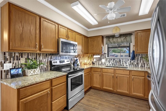 707 Golden Beach Dr, Buchanan Dam, TX 78609 - kitchen with stainless steel appliances, a sink, a ceiling fan, backsplash, and ornamental molding