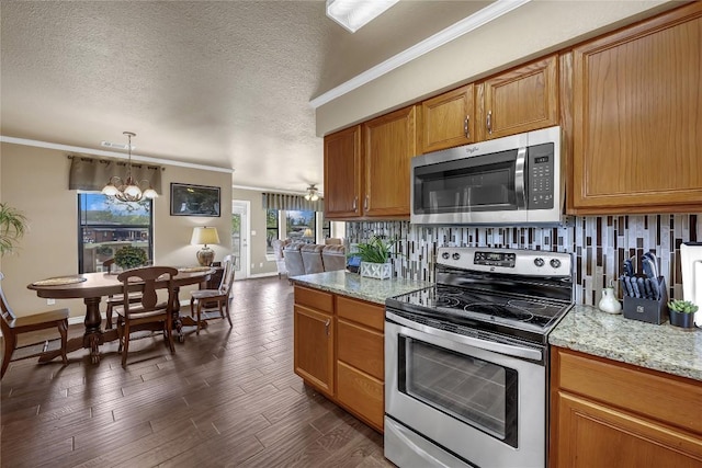 707 Golden Beach Dr, Buchanan Dam, TX 78609 - kitchen with stainless steel appliances, ornamental molding, a chandelier, backsplash, and dark wood-type flooring