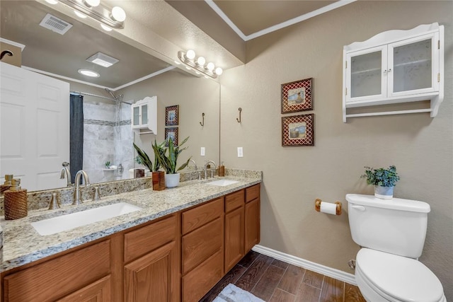 707 Golden Beach Dr, Buchanan Dam, TX 78609 - bathroom featuring ornamental molding, toilet, double vanity, baseboards, and wood finished floors