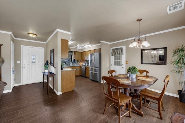 707 Golden Beach Dr, Buchanan Dam, TX 78609 - dining area featuring dark wood-style flooring, baseboards, ornamental molding, and a chandelier
