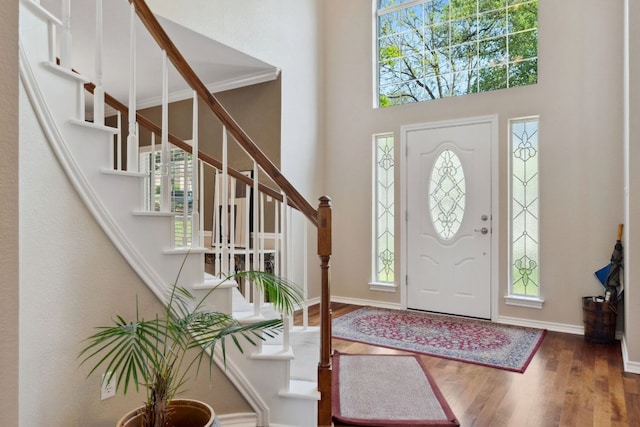 10406 Charette Cv, Austin, TX 78759 - foyer entrance featuring wood finished floors, plenty of natural light, stairway, a towering ceiling, and baseboards
