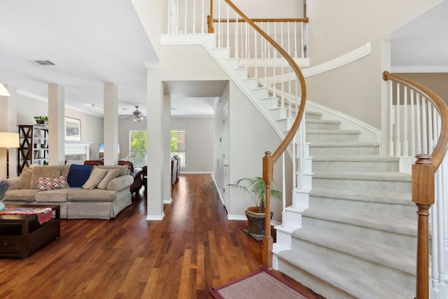 10406 Charette Cv, Austin, TX 78759 - living room featuring dark wood-style flooring, crown molding, stairs, ceiling fan, and baseboards