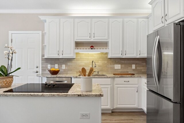 10406 Charette Cv, Austin, TX 78759 - kitchen with freestanding refrigerator, a sink, crown molding, white cabinets, and black electric stovetop