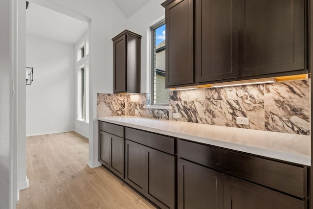1800 Sauterne Dr, Leander, TX 78641 - kitchen featuring light wood-style flooring, light countertops, backsplash, and dark brown cabinets