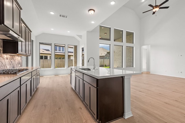 1800 Sauterne Dr, Leander, TX 78641 - kitchen with open floor plan, stainless steel gas stovetop, light wood finished floors, recessed lighting, and high vaulted ceiling