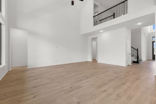 1800 Sauterne Dr, Leander, TX 78641 - unfurnished living room featuring a high ceiling, stairway, light wood-style flooring, and a ceiling fan
