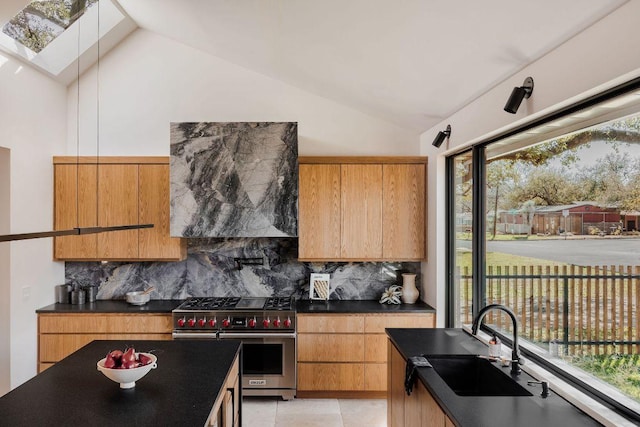 1202 Fieldcrest Dr, Austin, TX 78704 - kitchen featuring luxury range, dark countertops, vaulted ceiling, tasteful backsplash, and modern cabinets