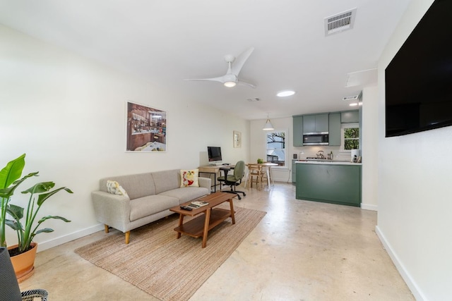 239 Brahan Blvd, San Antonio, TX 78215 - living room featuring concrete floors, baseboards, a ceiling fan, and an office area