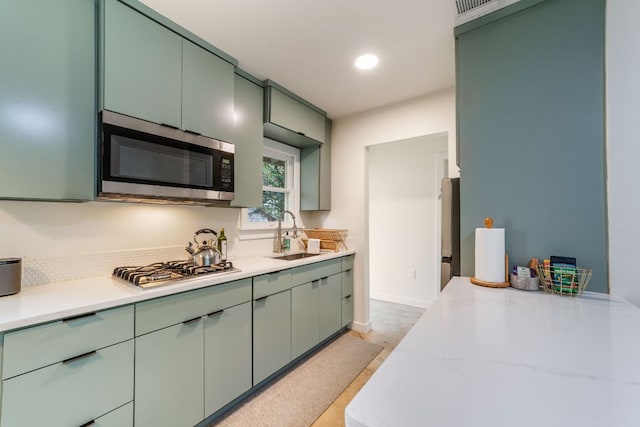 239 Brahan Blvd, San Antonio, TX 78215 - kitchen featuring a sink, appliances with stainless steel finishes, light countertops, and green cabinets