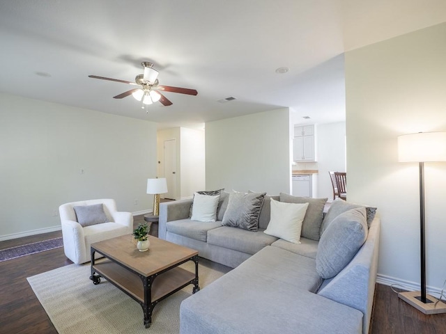living area with wood finished floors, baseboards, ceiling fan, and visible vents