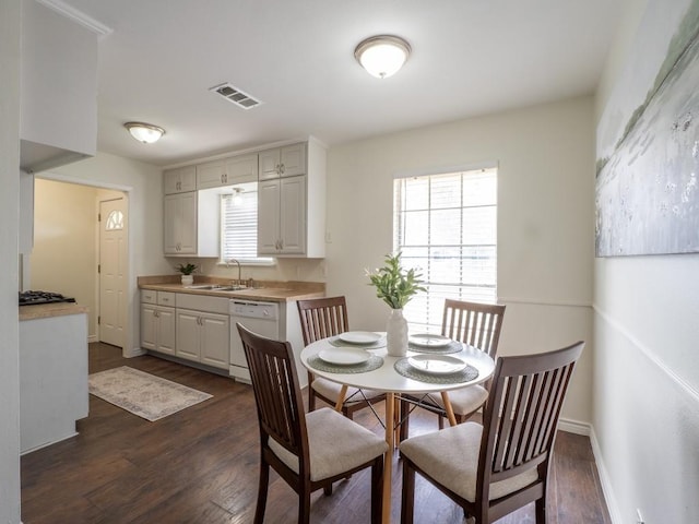 dining area with dark wood-type flooring, visible vents, and a healthy amount of sunlight