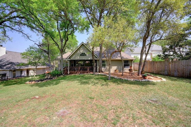 rear view of property with a lawn and fence