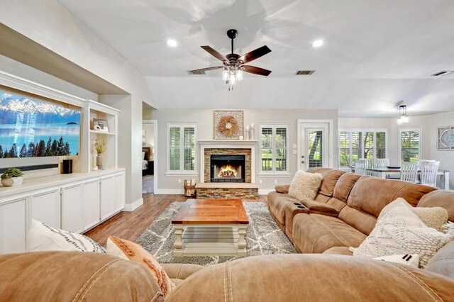 living room with ceiling fan, visible vents, vaulted ceiling, and wood finished floors