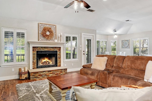 living area with a wealth of natural light, vaulted ceiling, and a ceiling fan