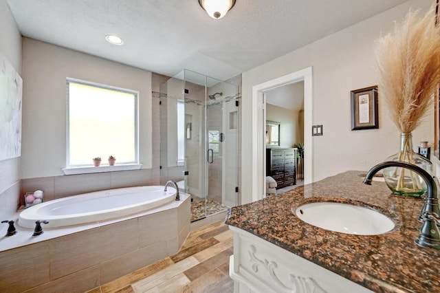 full bathroom with vanity, a stall shower, and a bath