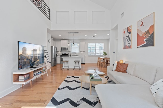 5911 Rubicon Run, Austin, TX 78745 - living area featuring light wood-type flooring, a high ceiling, and baseboards