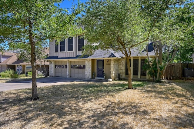 13109 New Boston Bnd, Austin, TX 78729 - view of front of home with an attached garage, stone siding, board and batten siding, and driveway