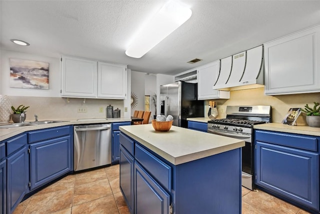 13109 New Boston Bnd, Austin, TX 78729 - kitchen with appliances with stainless steel finishes, blue cabinetry, range hood, a sink, and a textured ceiling