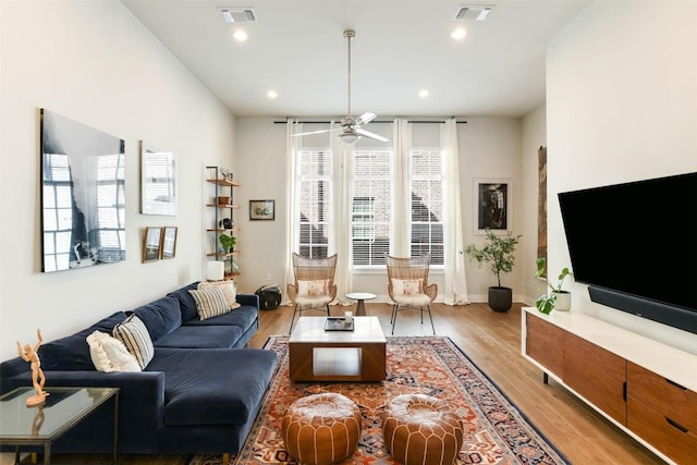 living area featuring visible vents, a ceiling fan, and wood finished floors