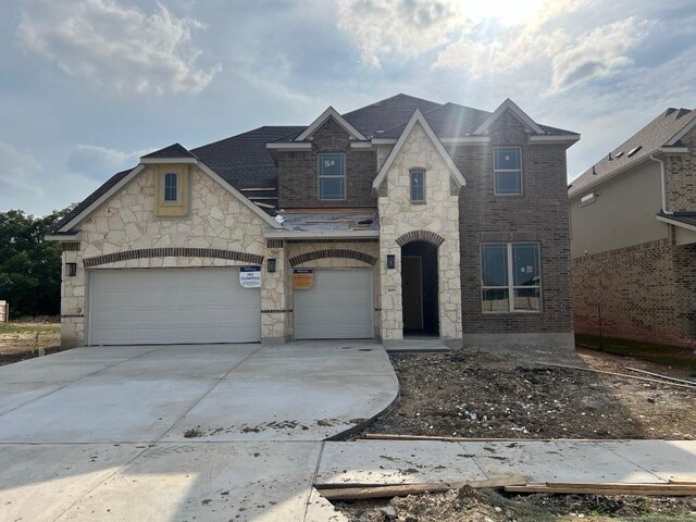 909 Landing Ln, Leander, TX 78641 - french provincial home featuring concrete driveway, stone siding, and brick siding