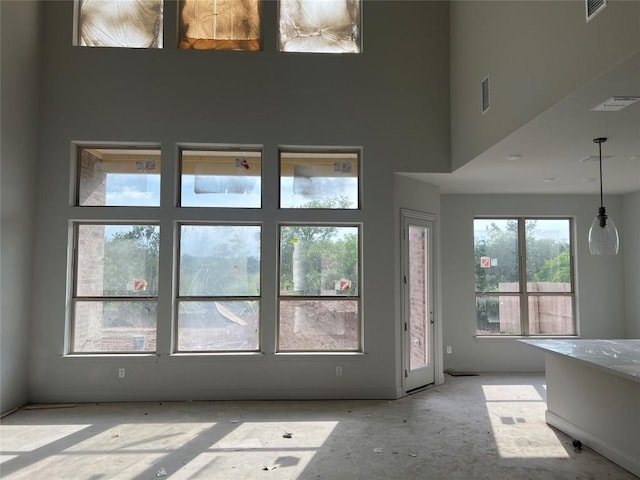 interior space featuring visible vents and a towering ceiling