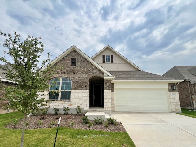 18204 Willow Sage Ln, Elgin, TX 78621 - traditional-style house with an attached garage, driveway, a front yard, a shingled roof, and stone siding