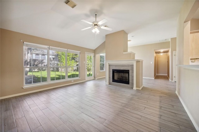 9120 Fainwood Ln, Austin, TX 78749 - unfurnished living room featuring a ceiling fan, vaulted ceiling, wood finished floors, and a tiled fireplace