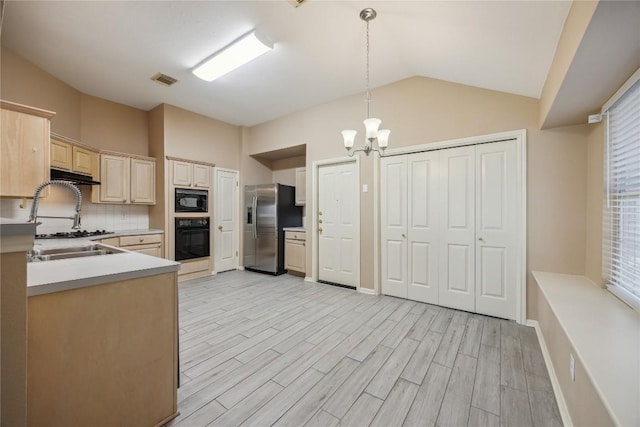 9120 Fainwood Ln, Austin, TX 78749 - kitchen featuring black appliances, under cabinet range hood, lofted ceiling, a chandelier, and backsplash