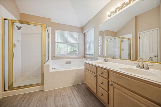9120 Fainwood Ln, Austin, TX 78749 - full bathroom featuring lofted ceiling, a stall shower, wood finished floors, a garden tub, and double vanity