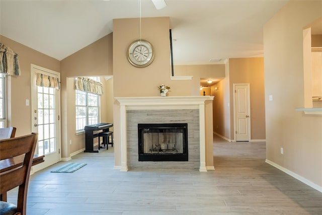 9120 Fainwood Ln, Austin, TX 78749 - living room with wood finished floors, a tile fireplace, ceiling fan, and lofted ceiling