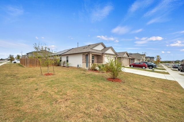 exterior space featuring concrete driveway, fence, an attached garage, brick siding, and a yard