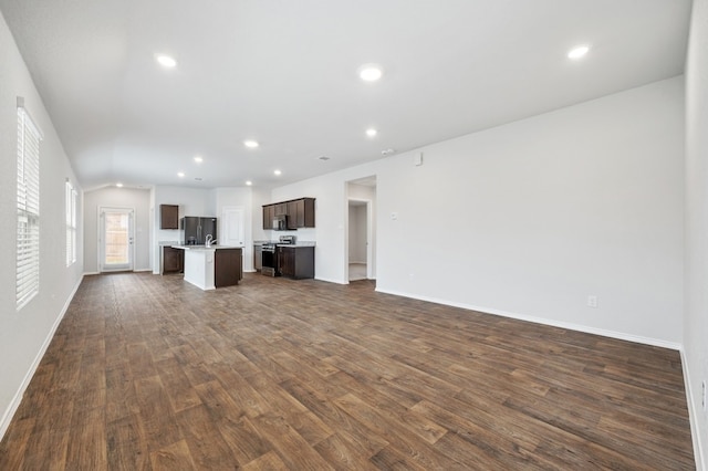 unfurnished living room with recessed lighting, baseboards, and dark wood finished floors