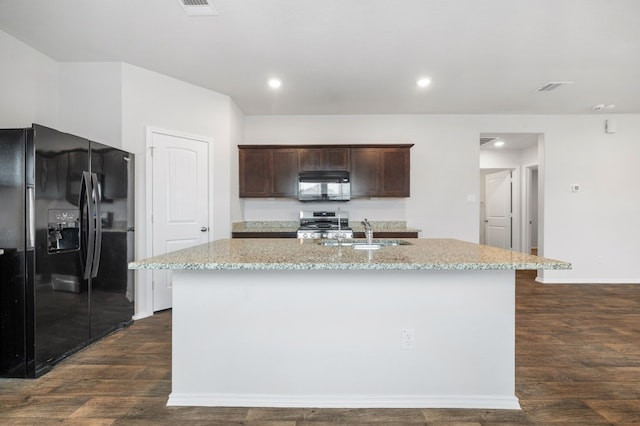 kitchen featuring dark wood-style flooring, dark brown cabinets, a sink, an island with sink, and black appliances