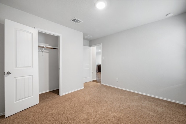 unfurnished bedroom featuring baseboards, visible vents, a closet, and carpet floors