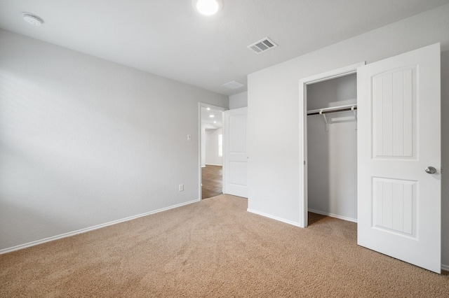 unfurnished bedroom with a closet, carpet flooring, visible vents, and baseboards