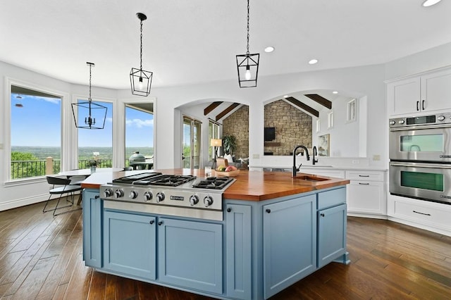 3416 Tarlton Ln, Austin, TX 78746 - kitchen featuring wood counters, stainless steel appliances, blue cabinetry, and recessed lighting