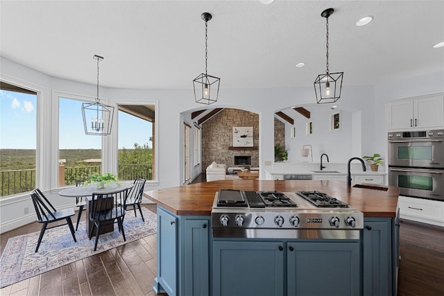 3416 Tarlton Ln, Austin, TX 78746 - kitchen with wooden counters, stainless steel appliances, a sink, dark wood-type flooring, and recessed lighting