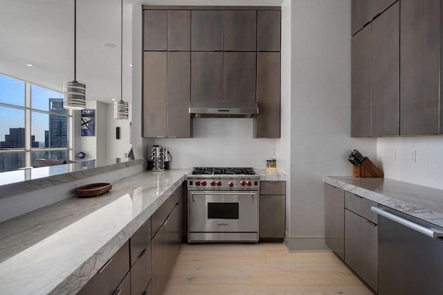 555 E 5th St Unit 2906, Austin, TX 78701 - kitchen with stainless steel appliances, light wood-style floors, under cabinet range hood, light stone countertops, and dark brown cabinetry