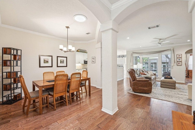 201 Texas Traditions, Georgetown, TX 78628 - dining area featuring arched walkways, crown molding, ceiling fan, wood finished floors, and decorative columns